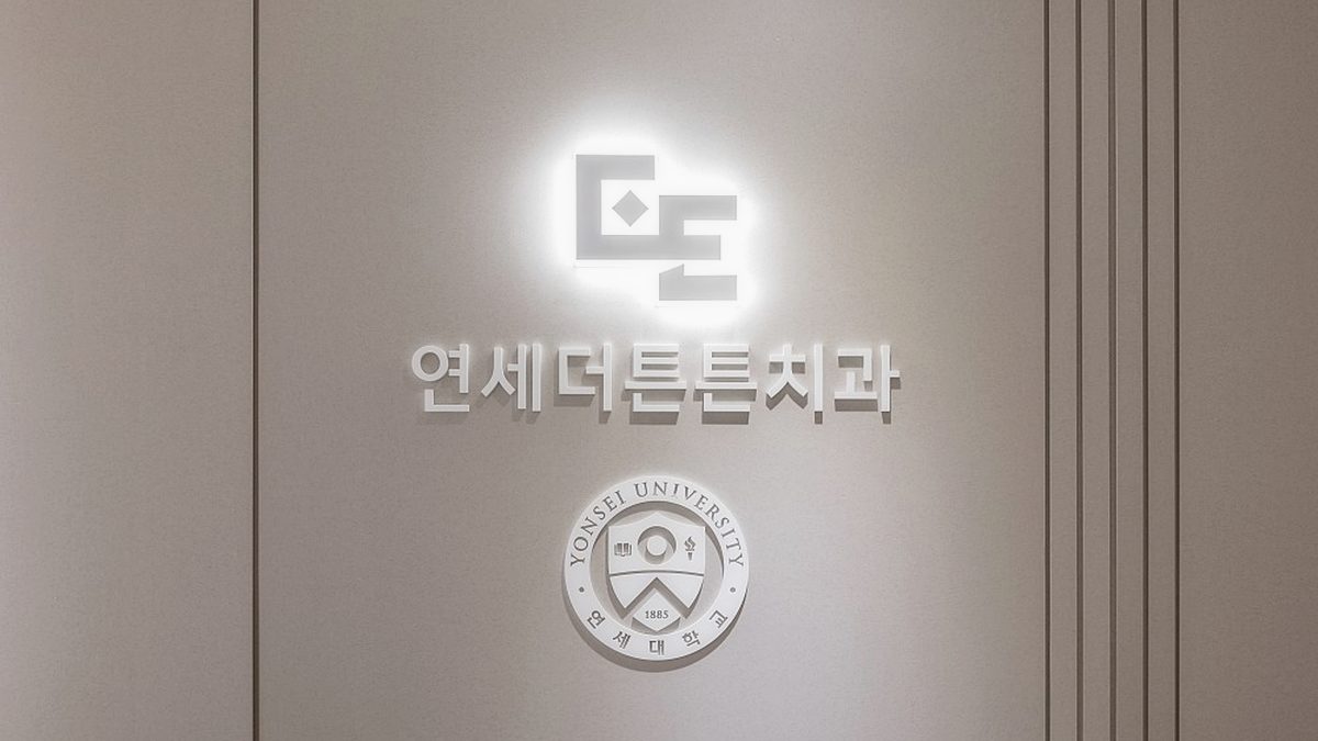 연세더튼튼치과 로비의 로고월 — 연세대학교 엠블럼과 병원 로고