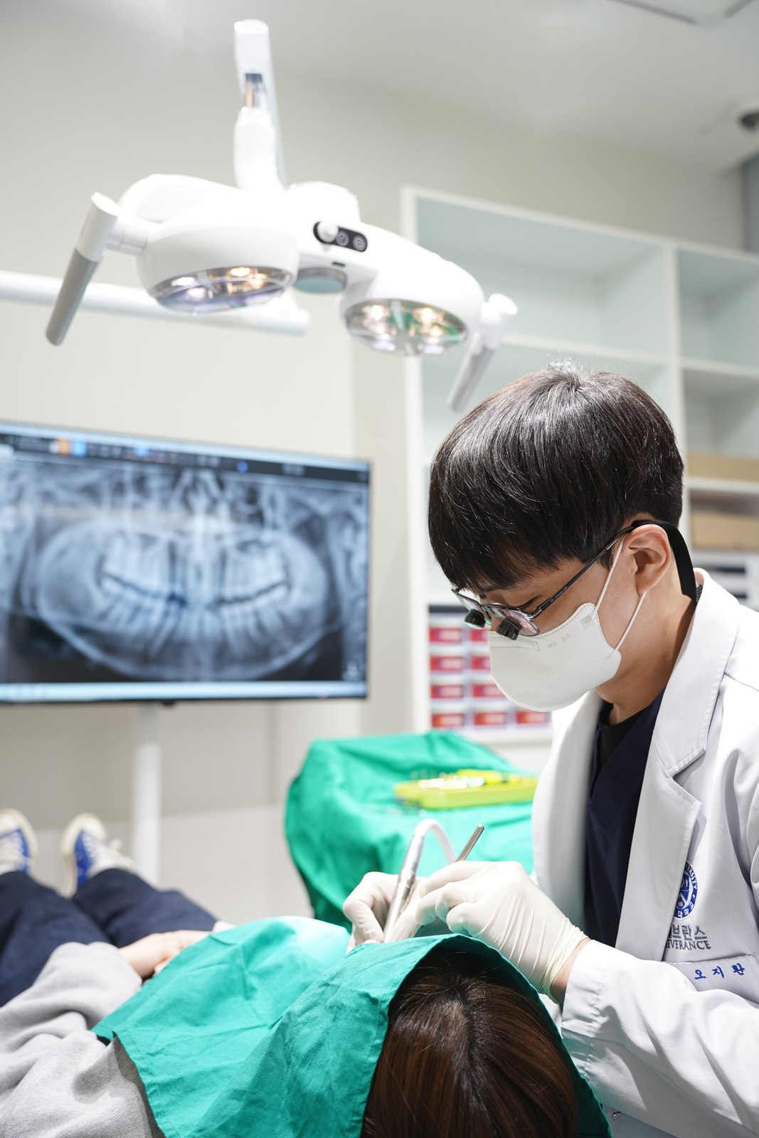 밝은 진료실에서 확대경을 착용하고 진료에 집중하는 연세더튼튼치과 오지환 대표원장